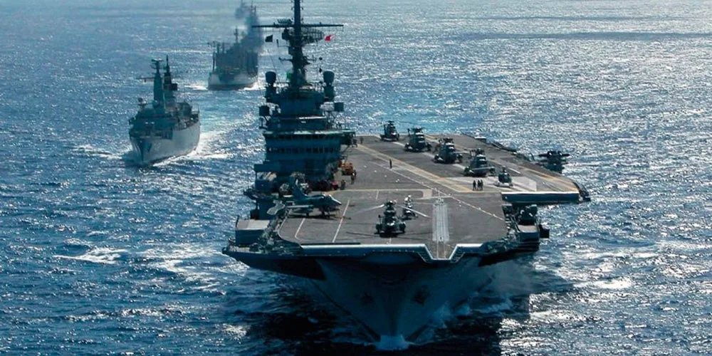 Porte-avions de la Marine nationale en mer avec son escorte, aéronefs sur le pont